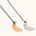 Gold crescent moon pendant with paisley patterns on adjustable black cord with brass beads